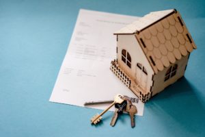 image of cardboard house with keys and a purchase document
